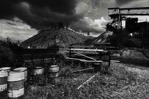 Stripa cinder heap with cloud formations and oil barrels