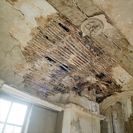 Crumbling plasterwork in one of the wings at Château Fossé, France.